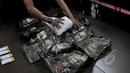 Petugas merapihkan barang bukti narkotiba saat konferensi pers di Kantor BNN, Jakarta, Kamis (16/4/2015). BNN menggagalkan transaksi narkotika jenis sabu seberat 10 kg dari Malaysia ke Indonesia. (Liputan6.com/Johan Tallo)