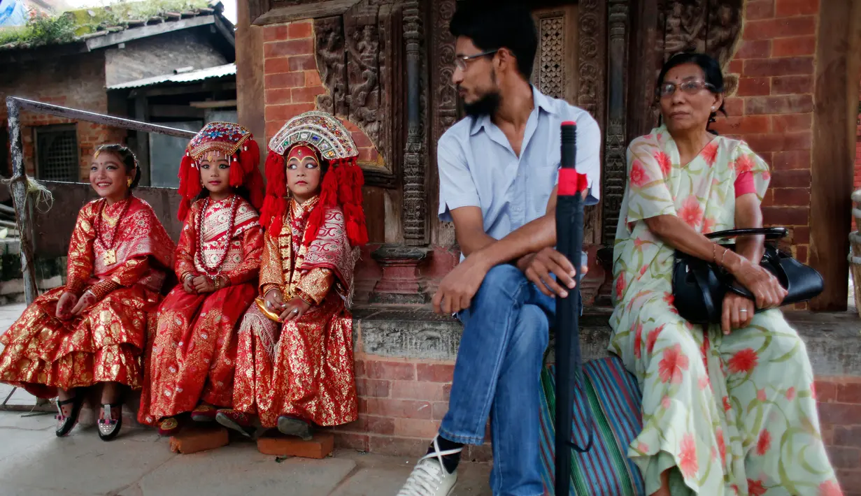 Tiga anak perempuan Nepal berpakaian seperti Dewi saat pemujaan Kumari di Hanuman Dhoka, Kathmandu, Nepal (4/9). Kumari adalah tradisi pemujaan untuk anak perempuan di bawah 9 tahun di Nepal. (AP Photo/Niranjan Shrestha)