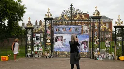 Seorang wanita mengambil gambar memorabilia Putri Diana di luar Istana Kensington, London, Selasa (29/8). Pernak-pernik serta bunga didedikasikan khusus untuk sang putri yang meninggal akibat kecelakaan mobil pada 31 Agustus 1997 (AP Photo/Alastair Grant)