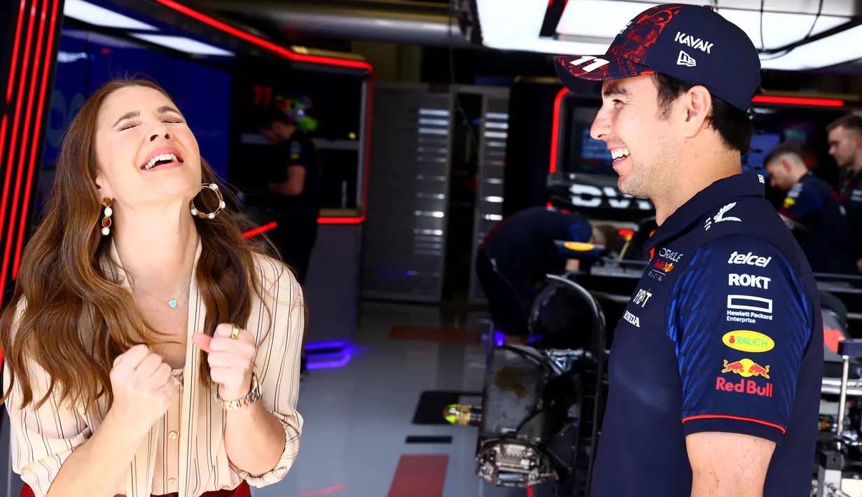 Aktris Amerika Serikat, Drew Barrymore (kiri) berbincang dengan salah satu pembalap Red Bull, Sergio Perez saat mengunjungi paddock tim Red Bull Racing menjelang Formula 1 GP Amerika Serikat 2023 di Circuit of The Americas, Austin, Texas, Kamis (19/10/2023) waktu setempat. (AFP/Mark Thompson)