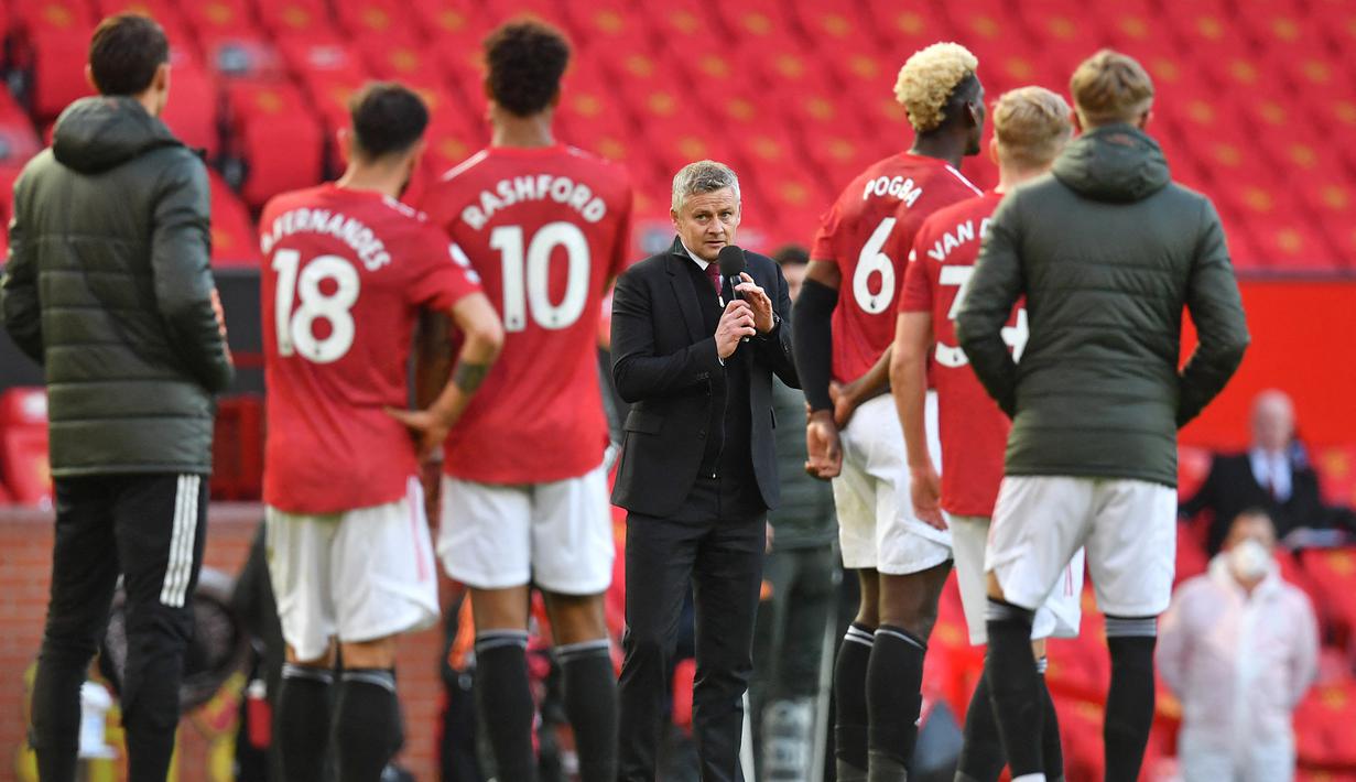 Manajer tim Manchester United, Ole Gunnar Solskjaer (tengah) menyapa para fans usai berakhirnya laga lanjutan Liga Inggris 2020/2021 pekan ke-37 melawan Fulham di Old Trafford Stadium, Rabu (18/5/2021). Manchester United bermain imbang 1-1 dengan Fulham. (AFP/Paul Ellis/Pool)