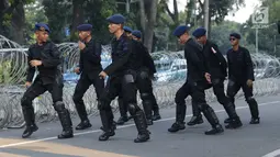 Personel Brimob menari bersama disela-sela berjaga di depan Gedung Mahkamah Konstitusi (MK), Jakarta, Selasa (25/6/2019). Kegiatan ini dilakukan untuk mengusir kejenuhan disela-sela pengamanan Gedung MK jelang sidang pembacaan putusan, Kamis (27/6). (Liputan6.com/Helmi Fithriansyah)