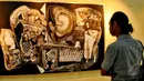 Suasana Pameran tunggal bertema 'Jakarta 18' karya Sri Warso Wahono, Jakarta, Senin (18/5/2015). Tampak seorang pengunjung sedang memperhatikan lukisan karya Sri Warso Wahono . (Liputan6.com/Yoppy Renato)