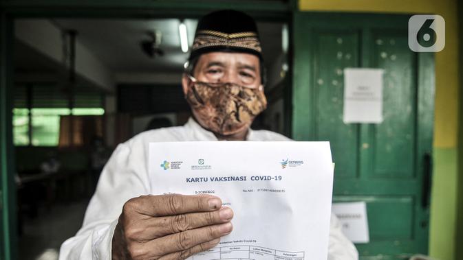 Warga lansia menunjukkan surat bukti vaksin COVID-19 di SDN 05 Penggilingan, Jakarta, Kamis (25/2/2021). Pemerintah berharap vaksinasi tahap kedua terhadap lansia selesai pada Mei 2021 guna menekan penyebaran COVID-19. (merdeka.com/Iqbal S. Nugroho)
