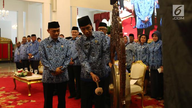 Presiden Joko Widodo (Jokowi) memukul gong saat membuka Rapat Kerja Nasional Korps Pegawai Republik Indonesia (KORPRI) 2019 di Istana Negara, Jakarta, Selasa (26/2) . (Liputan6.com/Angga Yuniar)