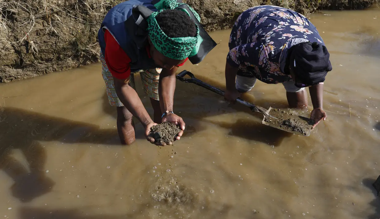 Orang-orang menggali apa yang mereka yakini sebagai berlian setelah penemuan batu tak dikenal di desa KwaHlathi dekat Ladysmith, Afrika Selatan (15/6/2021). Lebih dari 1.000 orang berbondong-bondong mendatangi tanah luas di Desa KwaHlathi untuk mencari batu yang diyakini berlian. (AFP/Phill Magakoe)