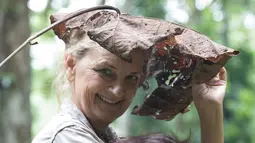 Dokter primatologi Dr. Signe Preuschoft menggendong orangutan yatim piatu di Sekolah Hutan Orangutan yang baru dibuka di Kalimantan Timur, 22 Mei 2018. Sekolah ini menjadi tempat mengajari orangutan agar bisa bertahan hidup di alam liar (HO/FOUR PAWS/AFP)