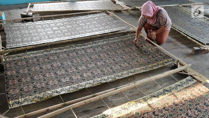 Seorang ibu membuat batik di Kampung Batik Puswasedar kawasan Geopark Ciletuh, Sukabumi, Jawa Barat, Sabtu (22/9). Batik di sini dikenal dengan batik pakulonan dan dijual dengan harga Rp 200 ribu hingga Rp 1,5 juta per lembar. (Merdeka.com/Arie Basuki)