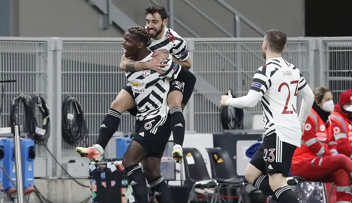 Gelandang Manchester United, Paul Pogba bersama Bruno Fernandes merayakan gol yang dicetaknya ke gawang AC Milan dalam laga leg kedua babak 16 besar Liga Europa 2020/2021 di San Siro Stadium, Milan, Kamis (18/3/2021). Manchester United menang 1-0 atas AC Milan. (AP/Antonio Calanni)
