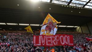 Suporter Liverpool memberikan dukungan saat melawan Wolverhampton pada laga Liga Inggris di Stadion Anfield, Liverpool, Minggu (12/5). Liverpool menang 2-0 atas Wolves. (AFP/Paul Ellis)