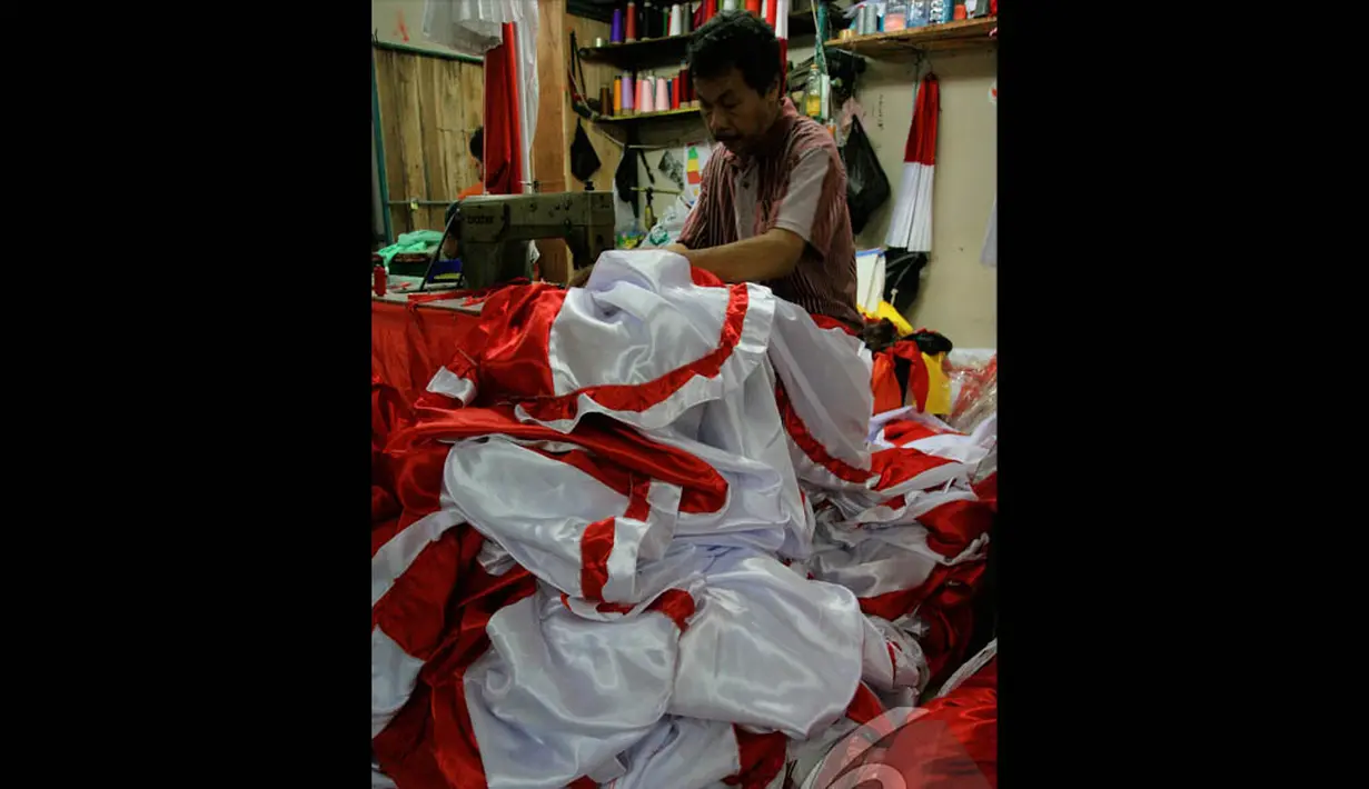 Seorang penjahit tampak menyelesaikan pesanan bendera merah putih di Blok V Pasar Senen, Jakarta, Selasa (4/8/2014) (Liputan6.com/Faizal Fanani)