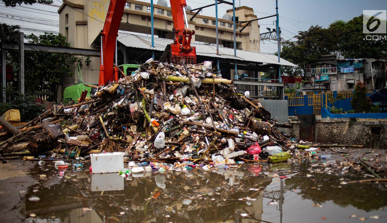Alat berat mengangkut sampah yang menumpuk di Pintu Air Manggarai, Jakarta, Selasa (4/12). Pembersihan dilakukan untuk melancarkan aliran sungai dan mencegah datangnya banjir saat memasuki musim hujan di wilayah tersebut. (Liputan6.com/Faizal Fanani)