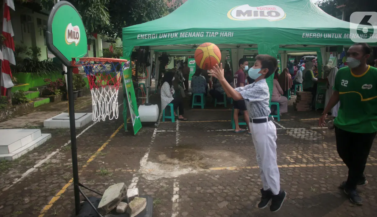 Siswa melempar bola basket sebelum mengikuti vaksinasi di SDN Jatiasih Bekasi (17/03/2022). Olahraga ringan bertujuan agar anak tetap tenang selama mengikuti vaksinasi dan bentuk komitmen dalam mewujudkan anak Indonesia yang sehat dan aktif menghadapi kegiatan PTM Terbatas. (Liputan6.com/HO/Milo)