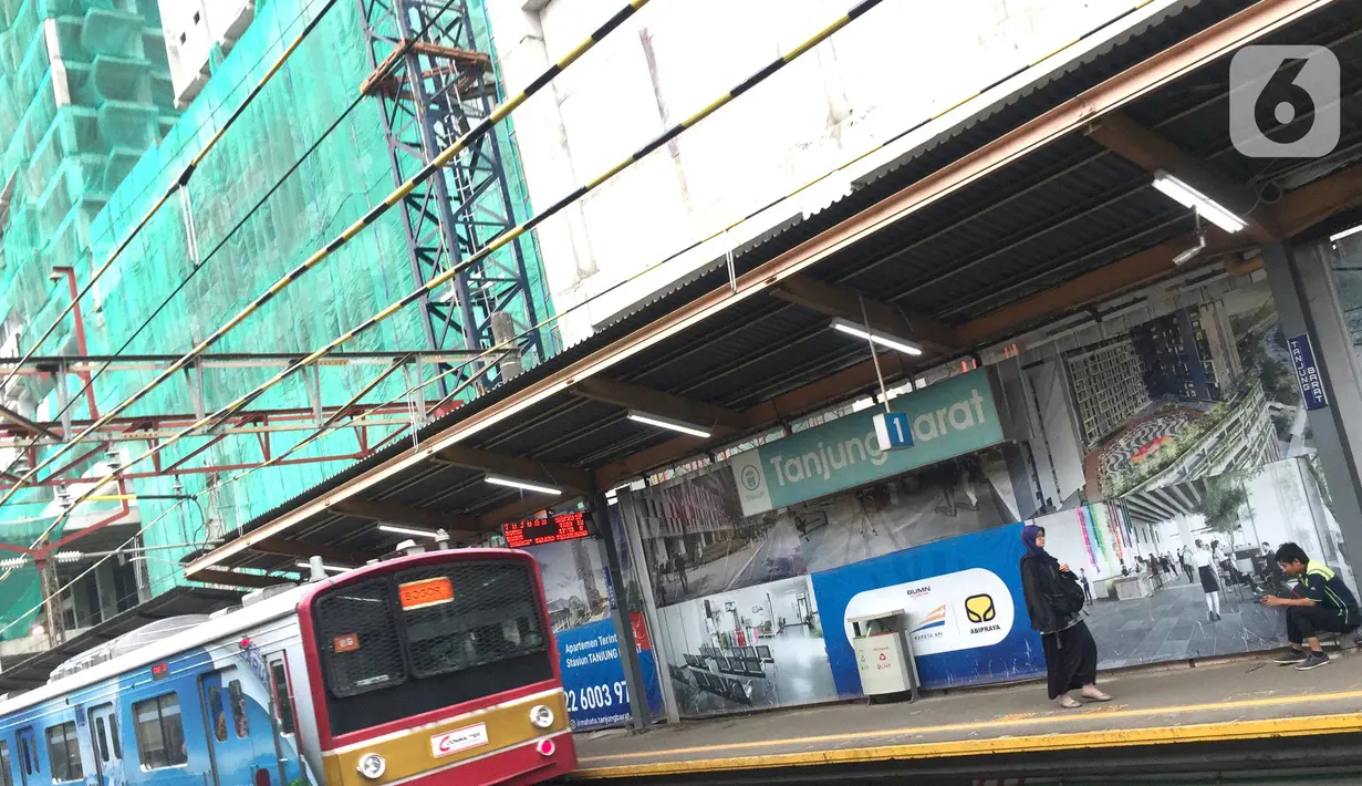 Kereta commuterline melintas dekat proyek pembangunan Apartemen Mahata Tanjung Barat di sekitar Stasiun Tanjung Barat, Jakarta, Kamis (30/1/2020). Proyek ini menempel Stasiun Tanjung Barat dan dekat dengan pusat perkantoran, pusat perbelanjaan, dan tempat rekreasi. (Liputan6.com/Immanuel Antonius)
