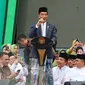 Presiden Joko Widodo atau Jokowi memberi sambutan dalam Harlah ke-73 Muslimat NU di SUGBK, Jakarta, Minggu (27/1). Jokowi datang dengan mengenakan kain sarung, jas, dan kopiah hitam. (Liputan6.com/Johan Tallo)