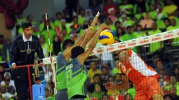 Dua pevoli putra Jakarta Pertamina Energi mencoba menahan smesh pemain Surabaya Samator, Lian Sem Estrada (kanan) di laga Pertamina Proliga 2015, GOR Dome Balikpapan, (8/2/2015). Surabaya Samator unggul 3-2. (Liputan6/com/Helmi Fithriansyah)