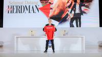 Pelatih baru Timnas Indonesia, John Herdman, berpose dengan menunjukkan jersey merah Skuad Garuda dalam konferensi pers perkenalannya di Hotel Mulia, Jakarta, Selasa (13/1/2026). (Bola.com/Bagaskara Lazuardi)