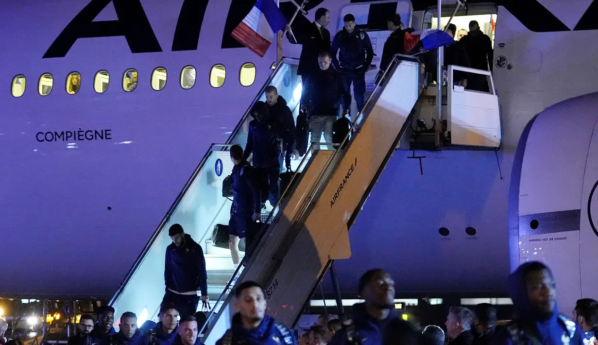 Skuad Prancis turun dari pesawat di Bandara Roissy, Paris. Mereka pulang dari Qatar sebagai runner up Piala Dunia 2022. (AP Photo/Michel Euler)