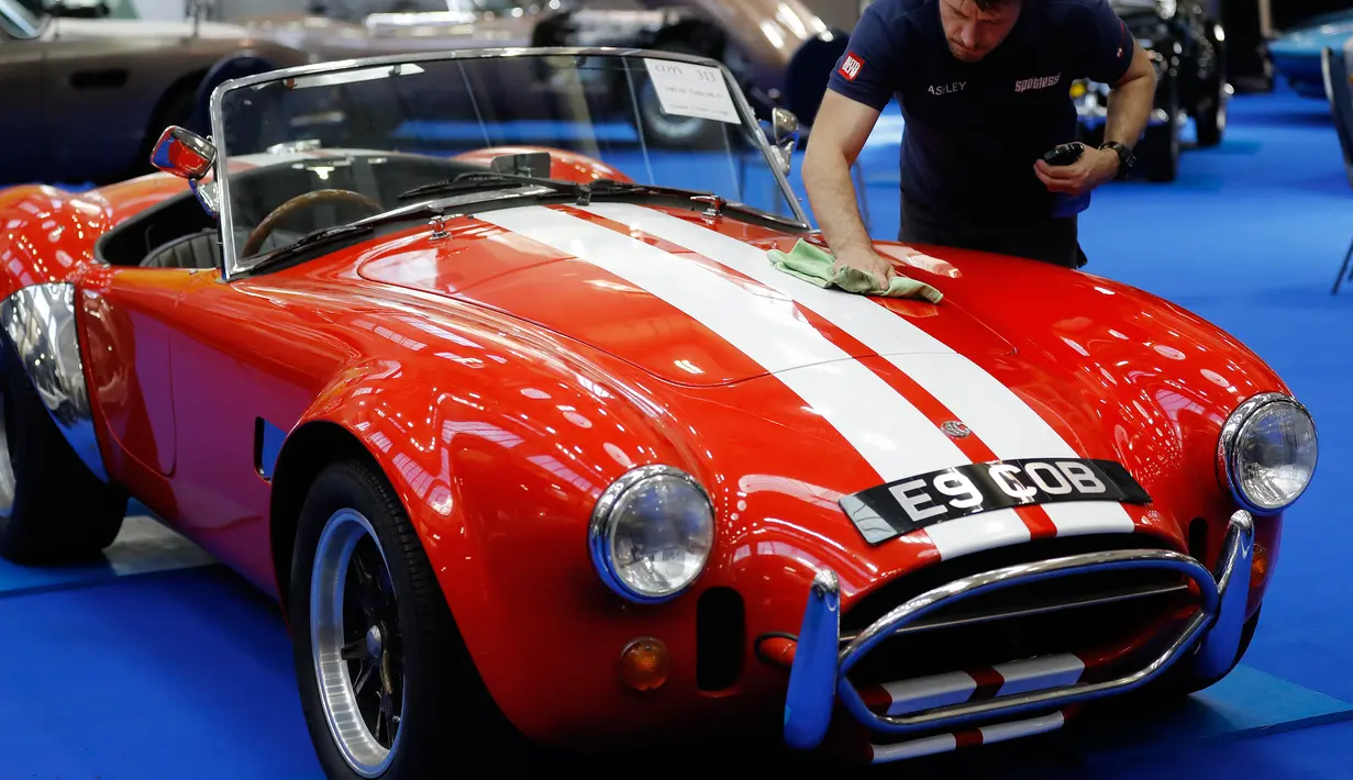 Pekerja memoles mobil AC Cobra MK4 keluaran tahun 1989 saat pelelangan Coys di London, Inggris (11/4). Mobil ini diperkirakan dilelang seharga 156,000-195.000 USD atau 138,000-173,000 euro. (AP Photo / Frank Augstein)