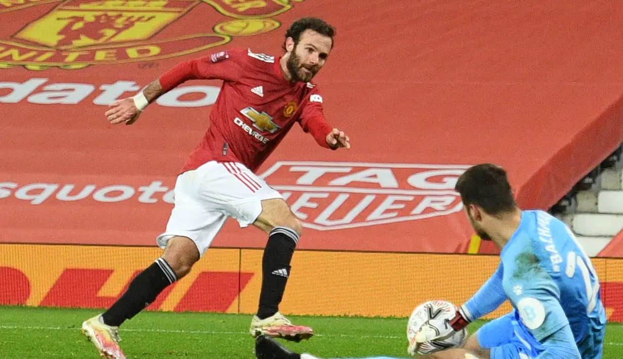 Kiper Watford, Daniel Bachmann (kanan) mementahkan tendangan gelandang Manchester United, Juan Matta dalam laga babak ke-3 Piala FA 2020/21 di Old Trafford, Sabtu (9/1/2021). Watford kalah 0-1 dari Manchester United. (AFP/Oli Scarff/Pool)