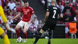 Bek Denmark, Pierre Emile Hojbjerg membawa bola dari kawalan bek Austria, Gernot Trauner pada laga keempat Grup A1 UEFA Nations League 2022/2023 di Parken Stadium, di Kopenhagen, Selasa (14/6/2022). Denmark menang atas Austria dengan skor 2-0. (Claus Bech/Ritzau Scanpix via AP)