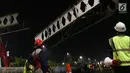 Pekerja menurunkan potongan rangka utama Jembatan Penyeberangan Orang Pasar Minggu, Jakarta, Sabtu (6/4). Proses pembongkaran JPO Pasar Minggu ini akan berlangsung hingga 7 April mendatang. (Liputan6.com/Helmi Fithriansyah)