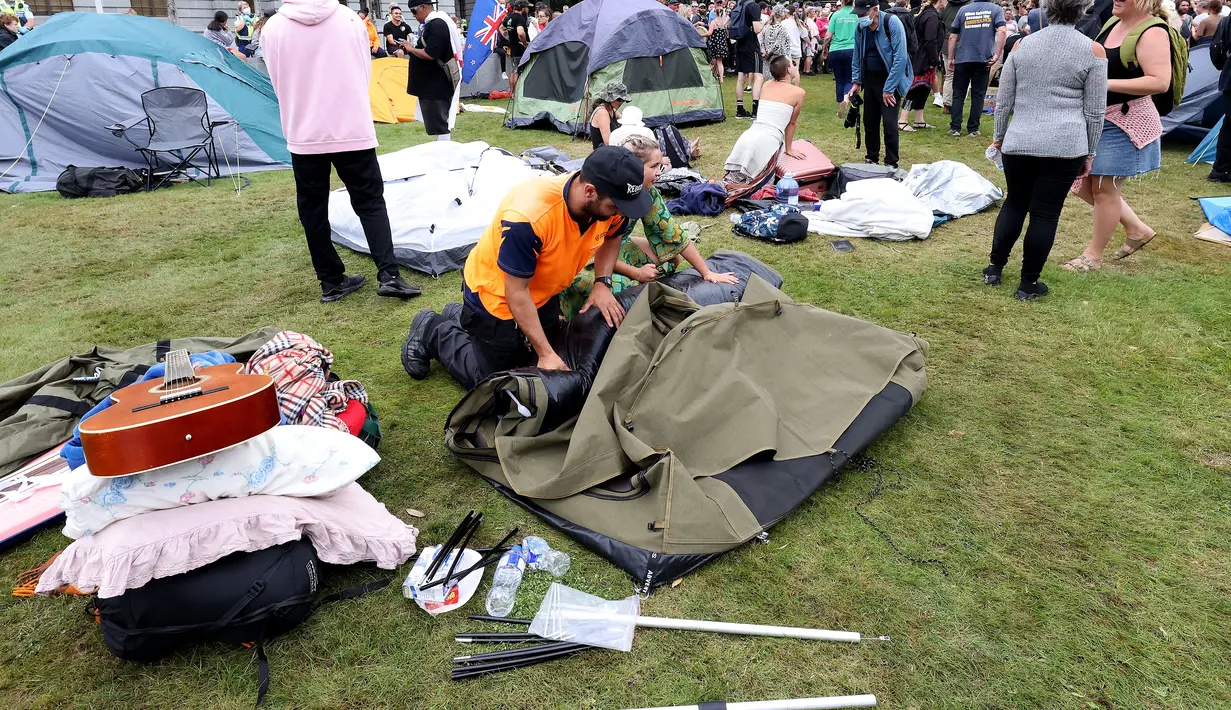 Para pengunjuk rasa mengepak tenda mereka di halaman parlemen pada hari ketiga demonstrasi menentang pembatasan Covid-19, yang terinspirasi oleh demonstrasi serupa di Kanada, di Wellington (10/2/2022). (AFP/Marty Melville)