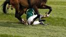 Kuda bernama Curious Carlos terjatuh saat ditunggai oleh Sean Bowen pada pacuan kuda festival nasional Crabbie Grand Liverpool, Inggris, Kamis (7/4/2016). Joki kuda ini terjatuh usai melewati pagar rintangan akhir. (Reuters / Andrew Boyers)