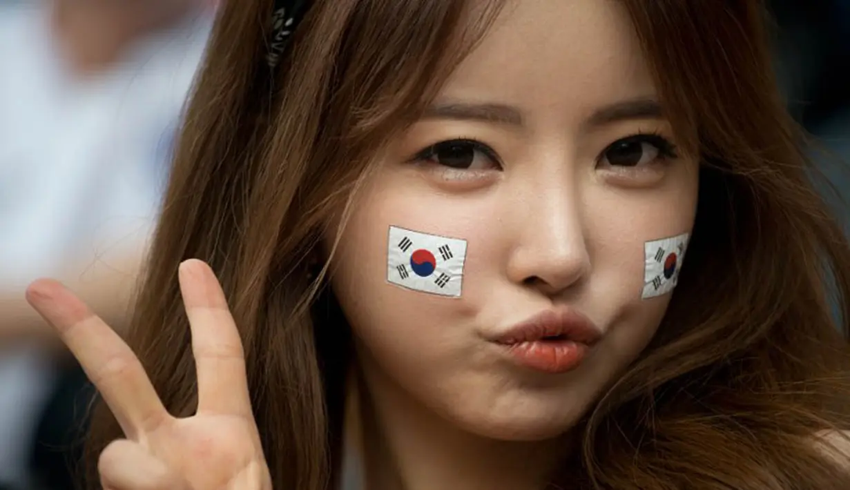 Gaya menggemaskan dari fans cantik Korea saat laga Korea selatan kontra Rusia pada 18 juni 2014 (AFP PHOTO/Ed Jones)