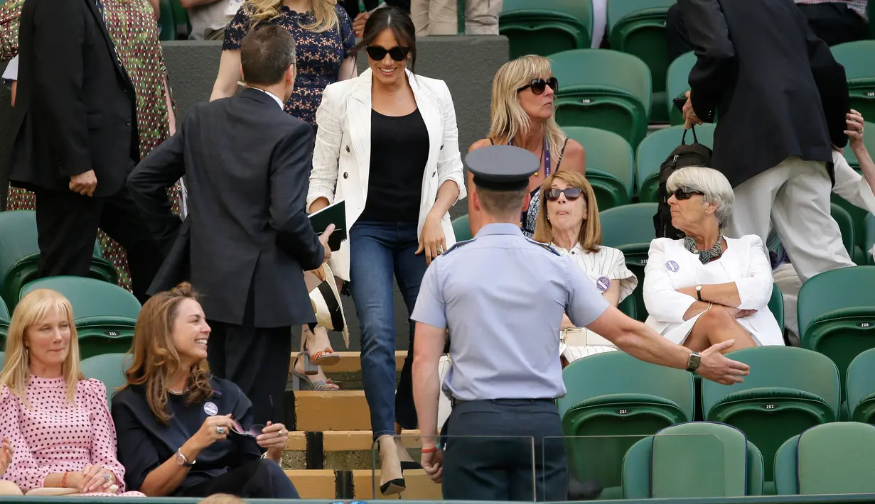 Meghan Markle tiba untuk menyaksikan sahabatnya yang juga petenis AS Serena Williams melawan Kaja Juvan dari Slovakia pada babak kedua Wimbledon di All England Lawn Tennis Club, London, Kamis (4/7/2019). Meghan tampil dalam balutan tank top dan jeans dengan blazer sebagai luaran. (AP/Tim Ireland)