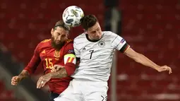 Gelandang Jerman, Julian Draxler, berebut bola dengan bek Spanyol, Sergio Ramos, pada laga Nation League di Mercedes-Benz Arena, Berlin, Jumat (4/9/2020) dini hari WIB. Jerman bermain imbang 1-1 atas Spanyol. (AFP/Thomas Kienzle)