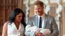 Pangeran Harry dan Meghan Markle berjalan membawa bayi laki-lakinya yang baru lahir di St George's Hall di Windsor Castle di Windsor, London (8/5/2019). Pangeran Harry menyatakan bahwa dia dan Meghan Markle masih memikirkan nama anak mereka. (AFP Photo/Dominic Lipinski)
