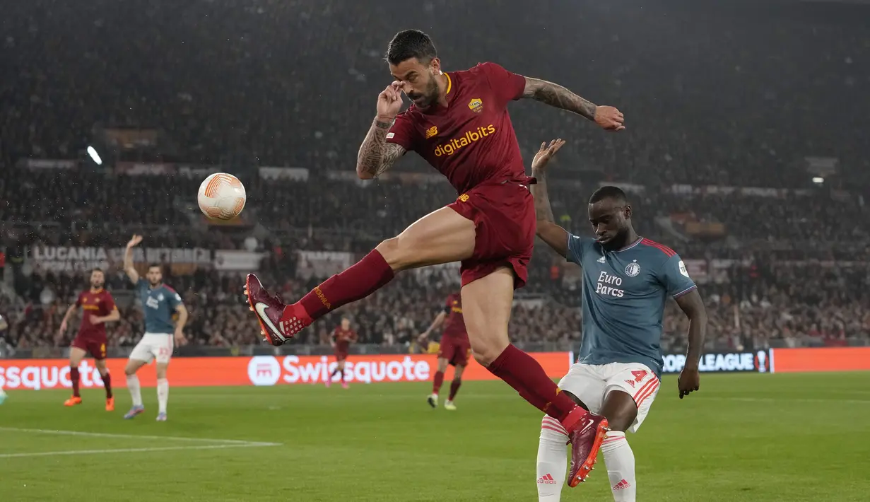 Gelandang AS Roma Lorenzo Pellegrini berebut bola dengan bek Feyenoord Lutsharel Geertruida  pada leg kedua perempat final Liga Europa 2022/2023 di Stadio Olimpico, Jumat (21/4/2023) WIB. (AP Photo/Alessandra Tarantino)