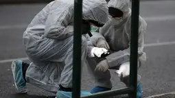 Petugas kepolisian mencari barang bukti usai ledakan bom di Pengadilan Banding di Athena, Jumat, (22/12). Sebuah ledakan dahsyat telah merusak kompleks pengadilan di pusat kota Athena. (AP Photo / Thanassis Stavrakis)