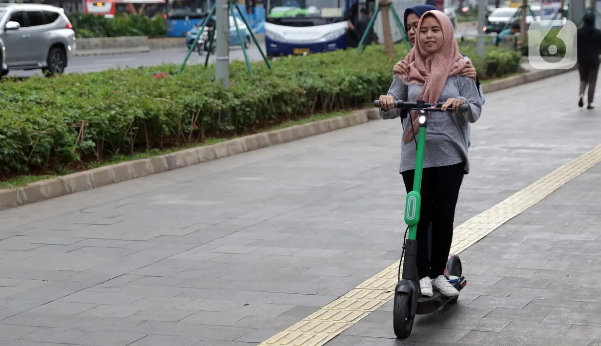 Pengguna otoped listrik Grabwheels melintas di trotoar Jalan Jenderal Sudirman, Jakarta, Kamis (14/11/2019). Pemprov DKI Jakarta melarang penggunaan otoped listrik di trotoar, Jembatan Penyeberangan Orang (JPO) serta pada pelaksanaan Hari Bebas Kendaraan. (Liputan6.com/Helmi Fithriansyah)