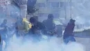Petani koka anti-pemerintah melarikan diri dari gas air mata yang ditembakkan oleh polisi anti huru hara di dekat pasar koka di La Paz, Bolivia, Kamis (23/9/2021). Menurut para petani koka, pihak berwenang menekan pasar tradisional mereka untuk menjual produk koka. (AP Photo/Juan Karita)