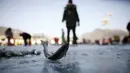 Seorang warga mendapatkan ikan trout atau disebut ikan air tawar selama acara Festival Es di sungai yang beku di Hwacheon, selatan dari zona demiliterisasi (DMZ) yang memisahkan dua Korea, (9/1/2016). (REUTERS/Kim Hong-Ji)