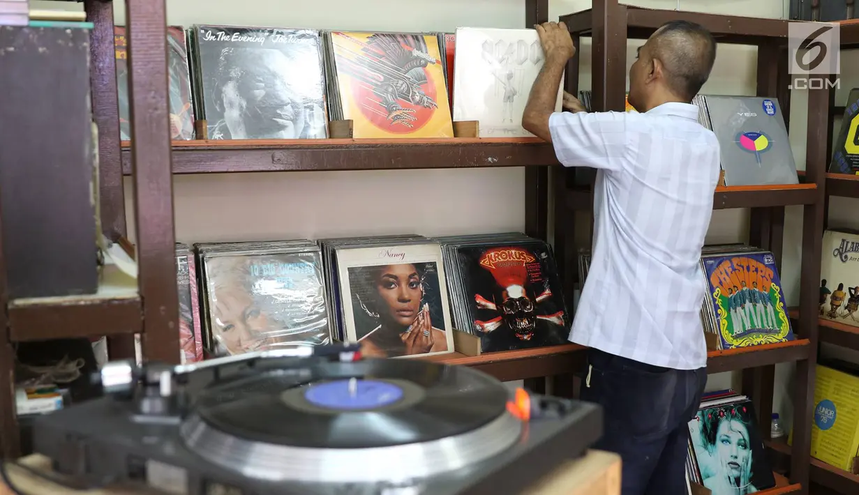 Iyan (56) merapikan piringan hitam dagangannya, Jakarta, Selasa (30/5). Piringan hitam klasik yang dijual berkisar Rp25ribu - Rp400ribu tersebut masih menjadi daya tarik bagi sejumlah penikmat musik di Tanah Air. (Liputan6.com/Immanuel Antonius)
