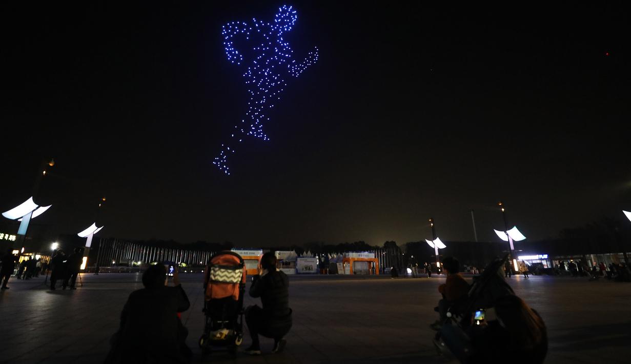 Sejumlah orang menikmati pertunjukan cahaya di Taman Olimpiade di Seoul, Korea Selatan. Sebuah pertunjukan cahaya yang menampilkan 315 drone digelar di Seoul pada Jumat (13/11). (Xinhua / Kementerian Agraria, Infrastruktur, dan Transportasi Korea Selatan)