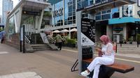 Seorang perempuan mengisi ulang daya ponsel pada stasiun Pengisian Listrik Bertenaga Surya atau Solar Charging Station di kawasan Transit Oriented Development (TOD) I Dukuh Atas, Jakarta, Rabu (10/11/2022). TOD I Dukuh Atas ini berada di tengah-tengah Stasiun MRT Duku Atas, Stasiun KA Bandara BNI City dan Stasiun Commuter Line Sudirman. (Liputan6.com/Johan Tallo)