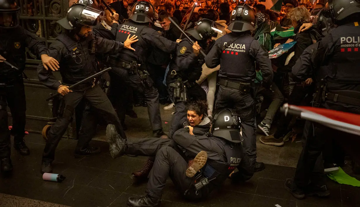 Polisi menangkap demonstran pro-Palestina saat mereka mencoba masuk ke stasiun kereta di Barcelona, Spanyol, Sabtu (11/11/2023). (AP Photo/Emilio Morenatti)