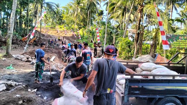 Warga Kampung Lahendong bersama personil Kodim 1309/Manado bahu membahu membangun jalan di kampung tersebut.