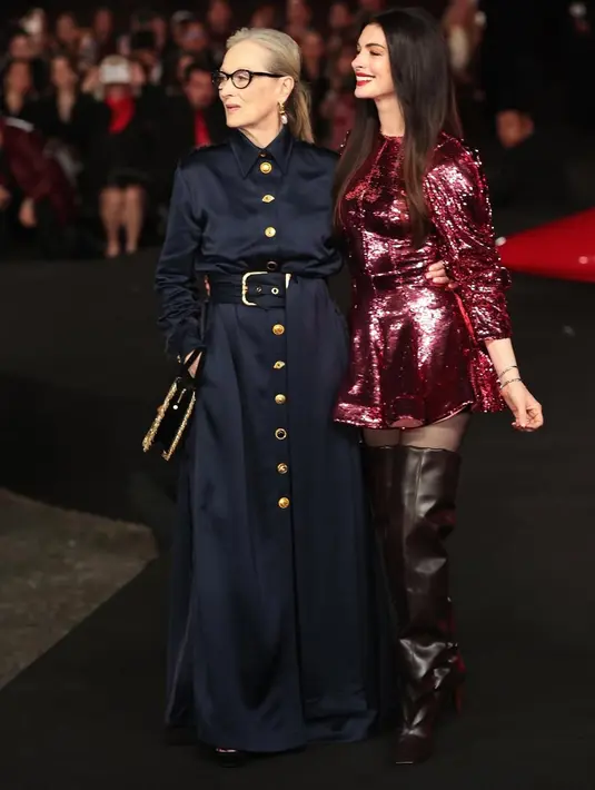 Mengoptimalkan tampilan, Anne terlihat mengimbangu gaunnya dengan tatanan rambut sleek. [Foto: Anne Hathaway]