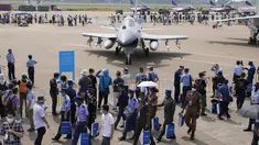 Perwira militer asing dan pengunjung berjalan melewati jet tempur J-10C dari Angkatan Udara Tentara Pembebasan Rakyat China (PLA) yang dipamerkan selama Airshow China 2021 di Zhuhai di provinsi Guangdong, China (38/9/2021). (AP Photo/Ng Han Guan)