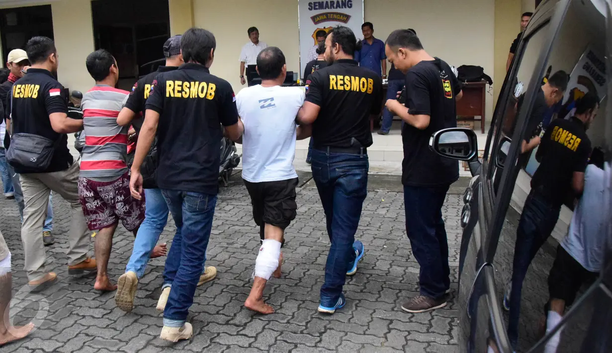 Petugas membawa salah satu komplotan pencuri spesialis rumah kosong saat rilis di Halaman Polrestabes Semarang , Minggu ( 19/6). Menjelang lebaran kejahatan pencurian rumah kosong meningkat. (Gholib)