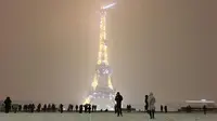 Suasana malam Menara Eiffel saat hujan salju di Paris Prancis (6/2). Ratusan orang terpaksa meninggalkan mobil mereka untuk tidur di tempat penampungan darurat akibat cuaca ekstrem yang melanda. (AFP Photo / Philippe Dupeyrat)