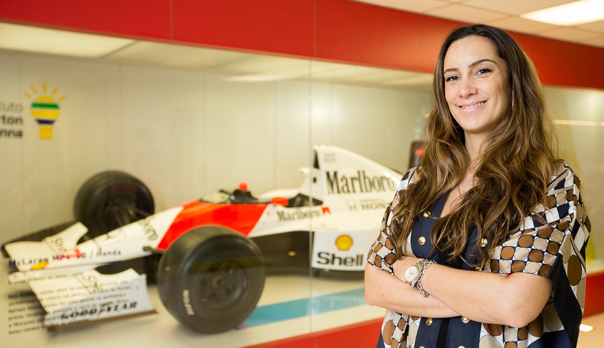 Bianca Senna, kemenakan Ayrton Senna yang juga direktur branding Institut Ayrton Senna berpose di depan mobil F1 yang pernah dipakai Ayrton Senna di Institut Ayrton Senna di Sao Paulo, Brasil. (AFP/Alexandre Schneider)