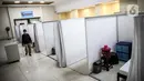 Petugas melintasi ruang isolasi mandiri pasien COVID-19 di Gelanggang Remaja Kecamatan Pademangan, Jakarta, Senin (28/9/2020). Sebanyak 30 bilik isolasi pasien Covid-19 disediakan dengan fasilitas tempat tidur, lemari, dan peralatan mandi. (Liputan6.com/Faizal Fanani)