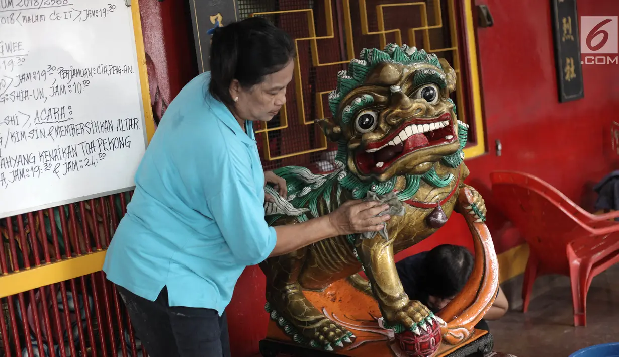 Seorang ibu membersihkan patung di Vihara Amurva Bhumi, Jakarta, Kamis (8/2). Berbagai persiapan dilakukan untuk menyambut perayaan Tahun Baru Imlek 2569. (Liputan6.com/Arya Manggala)