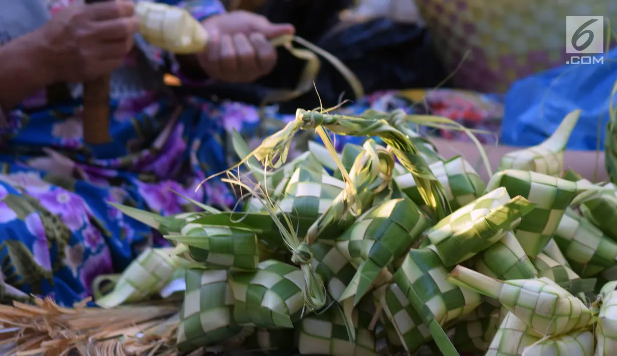 Pedagang merangkai janur menjadi kulit ketupat di Pasar Peterongan Semarang, Jawa Tengah, Kamis (14/6). Penjualan ketupat dan janur mulai marak menjelang lebaran dengan harga Rp 12.000 per sepuluh ketupat. (Liputan6.com/Gholib)